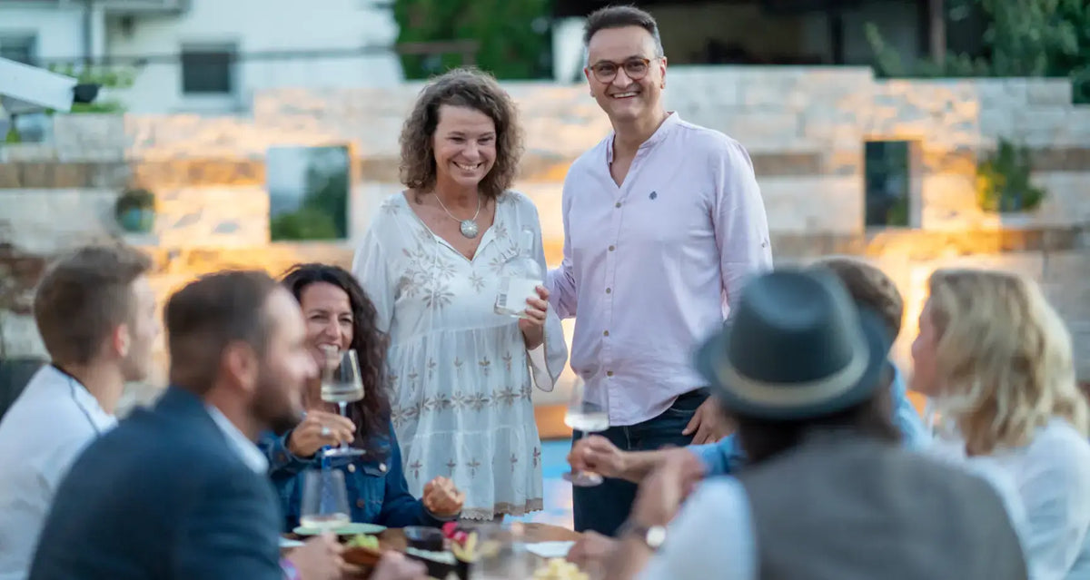 Wein-Tasting Event mit fröhlichen Gästen in geselliger Runde, kulinarische Entdeckung und Genuss im Freien.