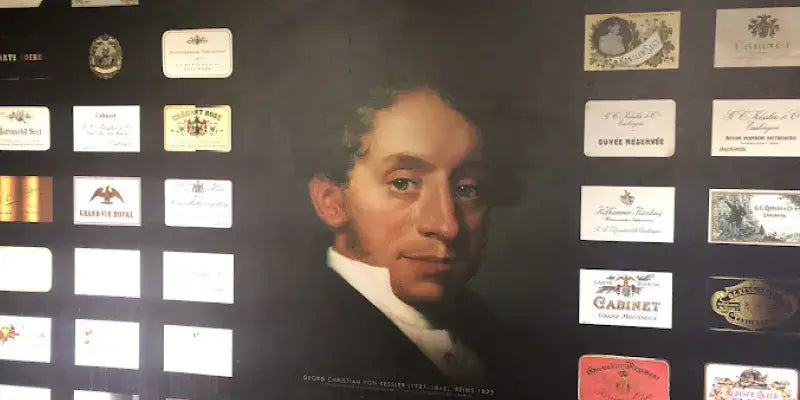 Kessler Sekt - Porträt eines historischen Weinguts mit verschiedenen Sektetiketten im Hintergrund.