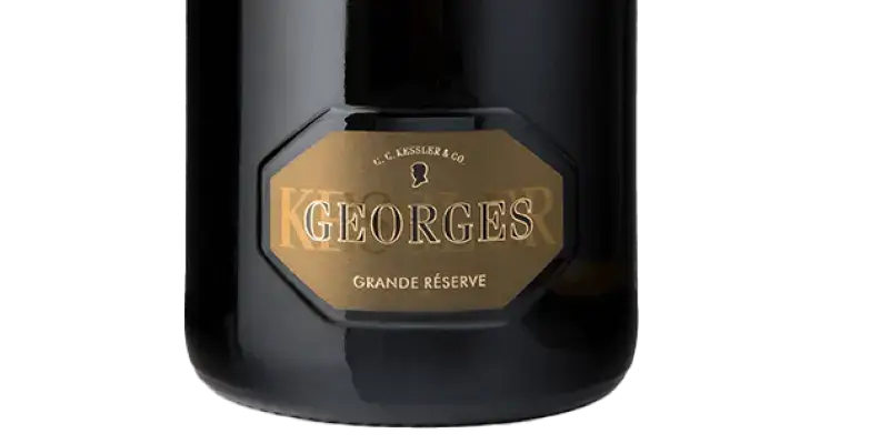 Kessler Georges Brut Flasche mit Goldetikett "Grande Réserve" auf schwarzem Hintergrund, Sektkunst bei TIME 2 TASTE.