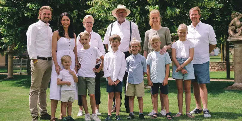 Weingut Lorenz & Söhne: Familienfoto im Grünen mit Weinberg-Hintergrund, ewig bewahrte Tradition und Zusammenhalt.