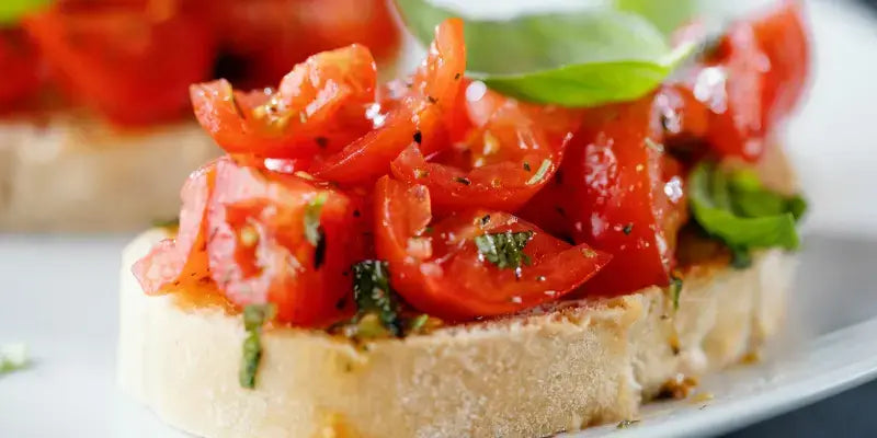 Bruschetta auf geröstetem Baguette mit frischen Tomaten und Basilikum, appetitlich angerichtet.
