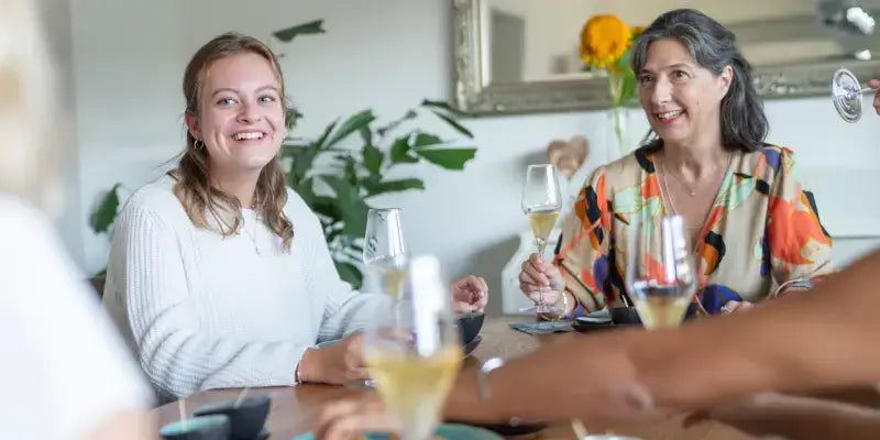 Wie entsteht prickelnder Genuss? Fröhliche Frauen genießen Schaumwein bei einem geselligen Treffen.