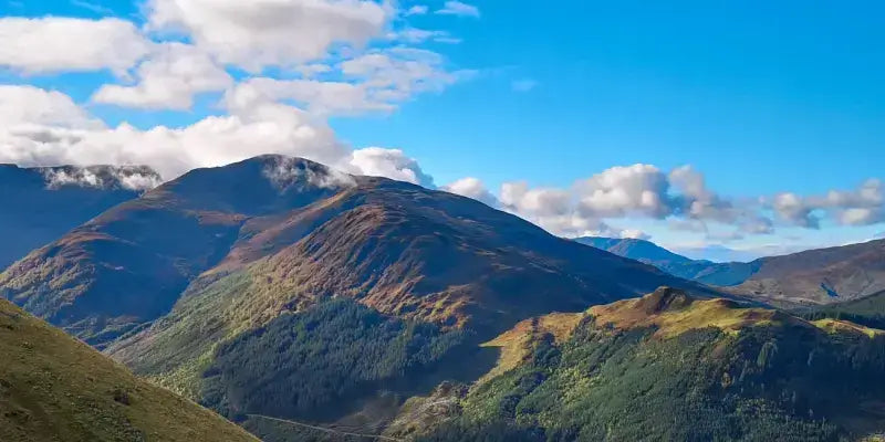 Ben Nevis: majestätische Berglandschaft der Highlands unter blauem Himmel, Hintergrund der Whiskyproduktion in Schottland.