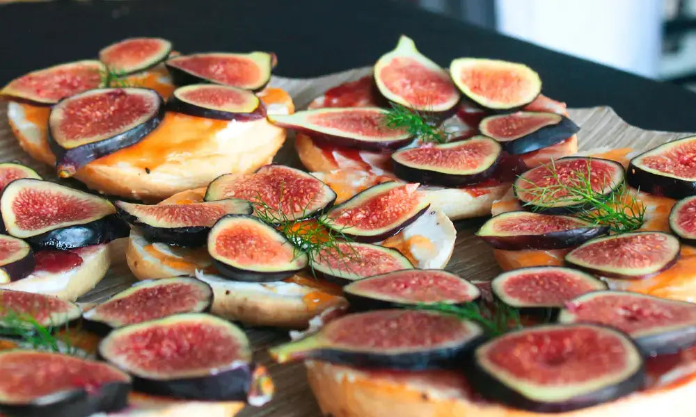 Feigenkonfitüre auf Broten, belegt mit frischen Feigen und Kräutern für eine harmonische Käse-Kombination.