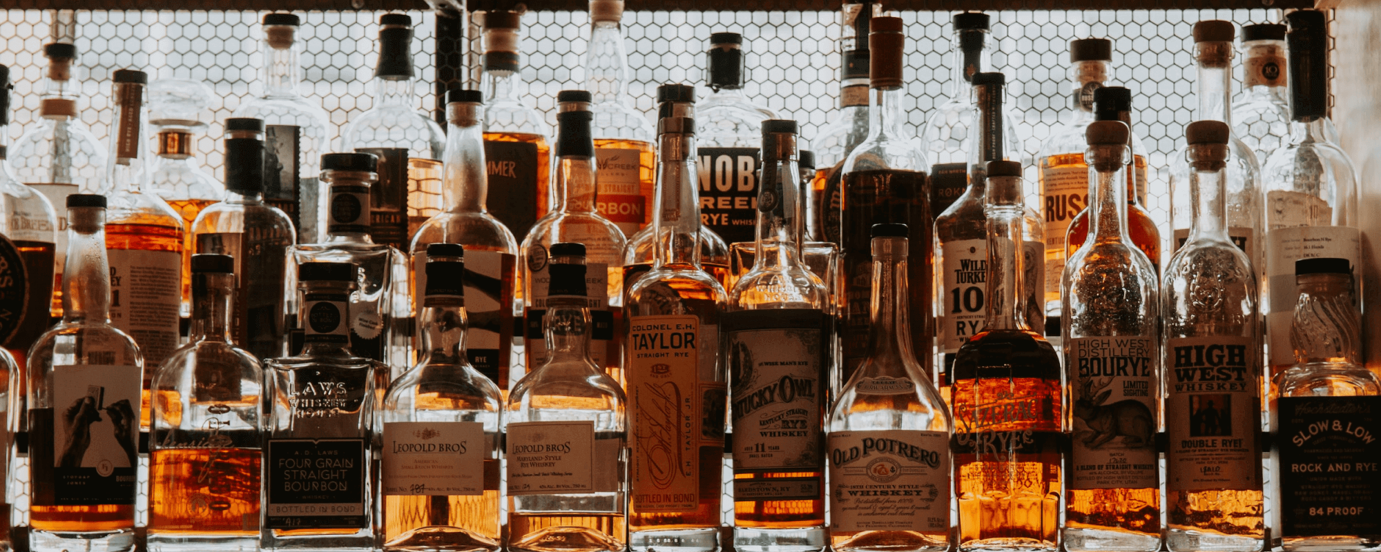 Whisky Sammlung mit verschiedenen Flaschen in eleganter Präsentation hinter einem Gitter.