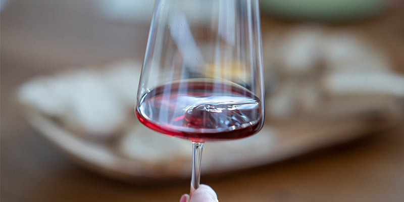 Rotwein in einem Glas mit Eiswürfel, hintergrund unscharf, ideales Bild für Getränkeartikel auf TIME 2 TASTE.