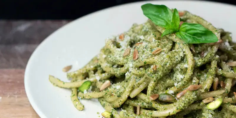 Basilikum Pesto: Frisch zubereitete Pasta mit Pesto, Basilikum, Pinienkernen und Parmesan auf einem Teller.
