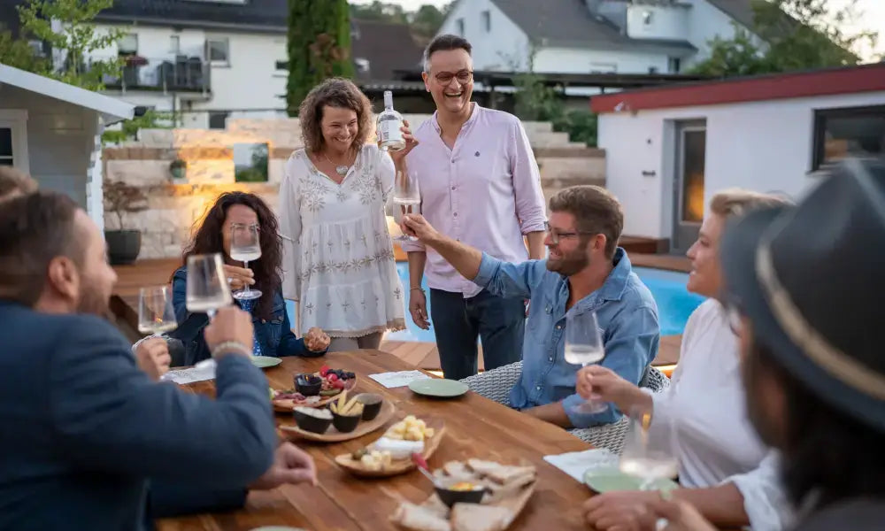 Perfektes Wein Tasting in Freiburg: Gruppe genießt Weine am Tisch mit Snacks und fröhlicher Atmosphäre.