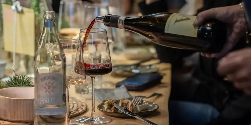 Around the World No 2 Wein-Tasting im Café Flora: Rotwein wird in ein Glas gegossen.