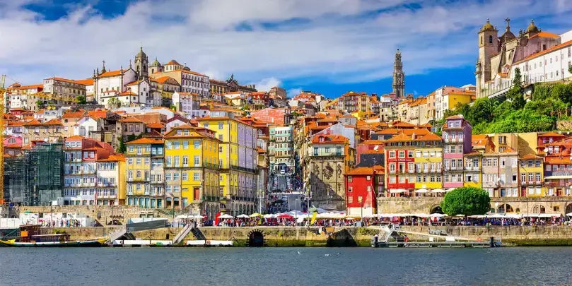 Gran Cruz: malerische Hafenansicht von Porto mit bunten Gebäuden und dem Douro-Fluss im Vordergrund.
