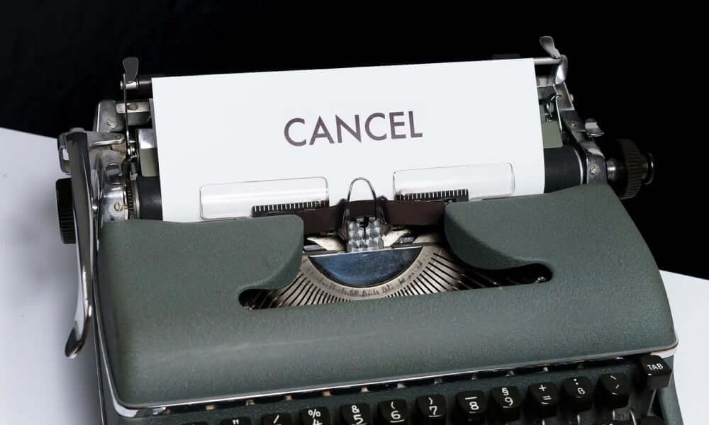 alte grüne Schreibmaschine mit einem beschriebenen Papier mit dem Wort cancel