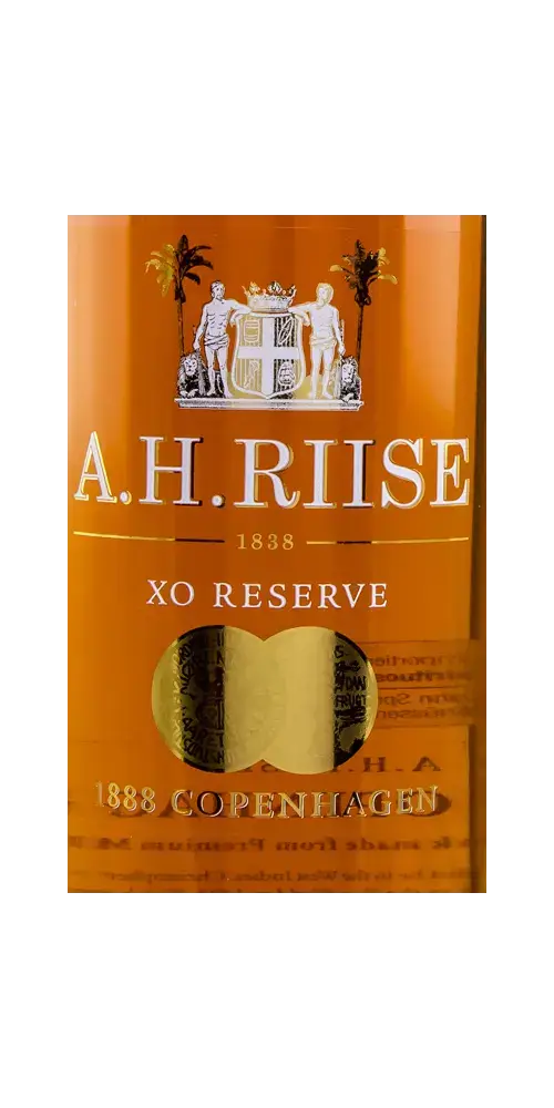 A.H. Riise XO 1888 Copenhagen Rumflasche mit goldenem Etikett und klarer Bernsteinfarbe als Höhepunkt.
