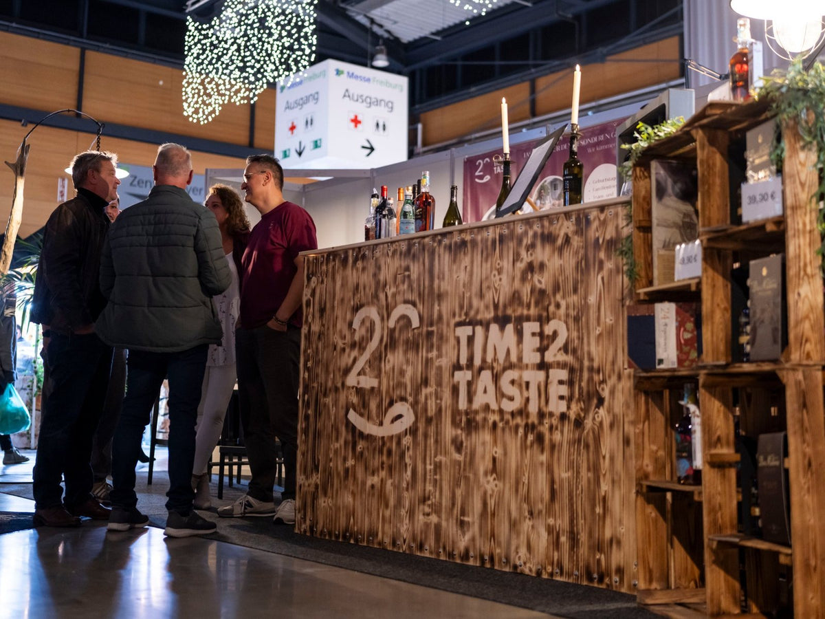 Mobile Bar von TIME2TASTE mit Holztheke und Gästen auf der Messe Freiburg