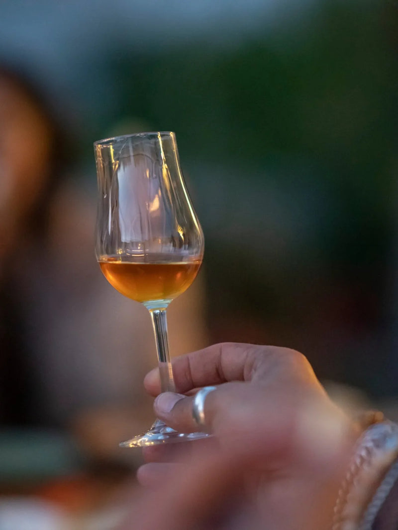 Ein Glas Rum in der Hand am Abend