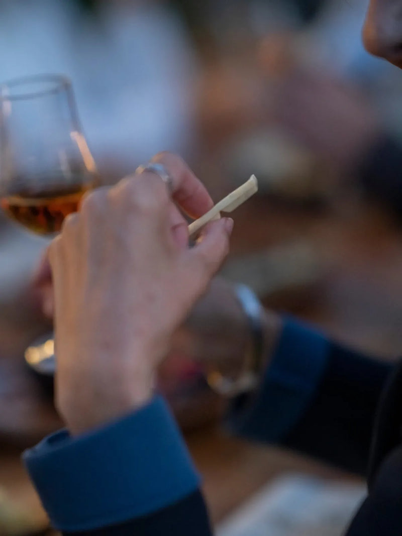 Ein Glas Rum und ein Stück Schokolade in der Hand