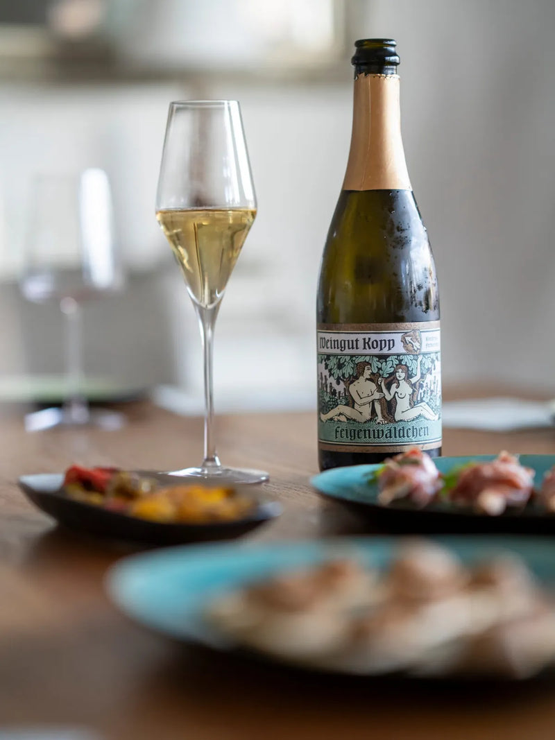 Flasche Sekt und ein gefülltes Sektglas auf dem Tisch