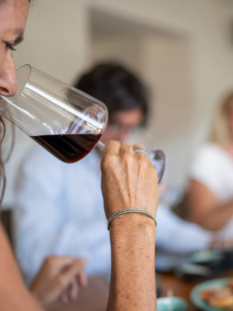 Ein Gast riecht bei der Weinprobe am Rotwein