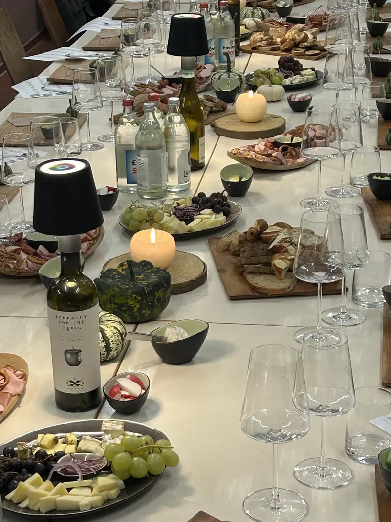 Lange Tafel mit Weingläsern, Fingerfood und Kerzen vor der Weinprobe