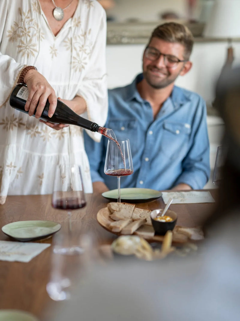 Rotwein wird bei einer privaten Weinprobe eingeschenkt