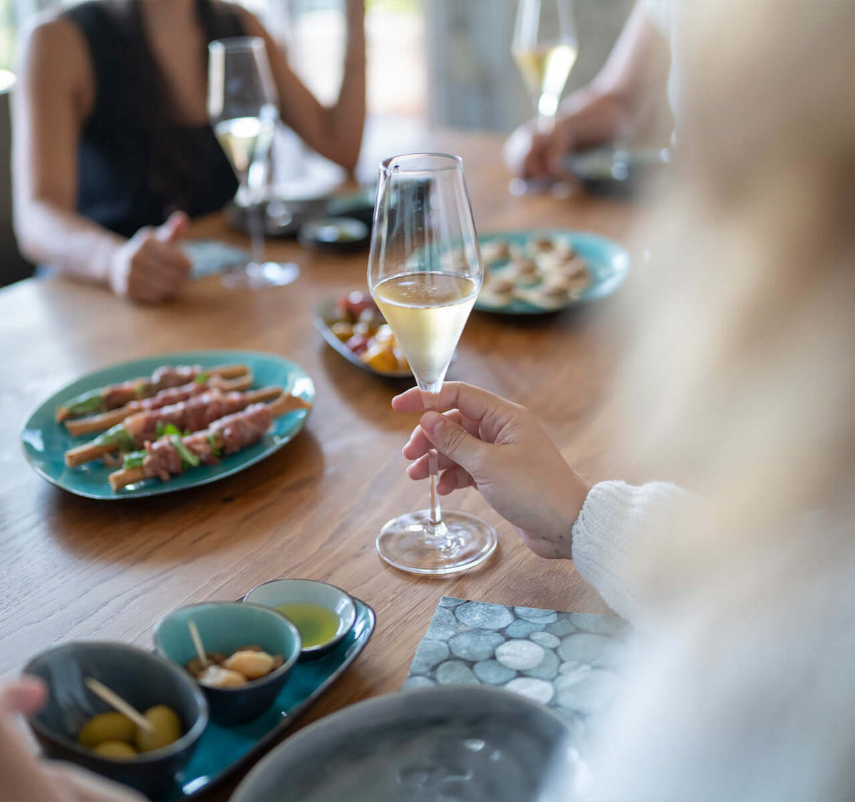 Schaumwein Tasting für Einsteiger: Stilvolle Geschirrarrangements mit Sekt und Feinkost auf einem Tisch.
