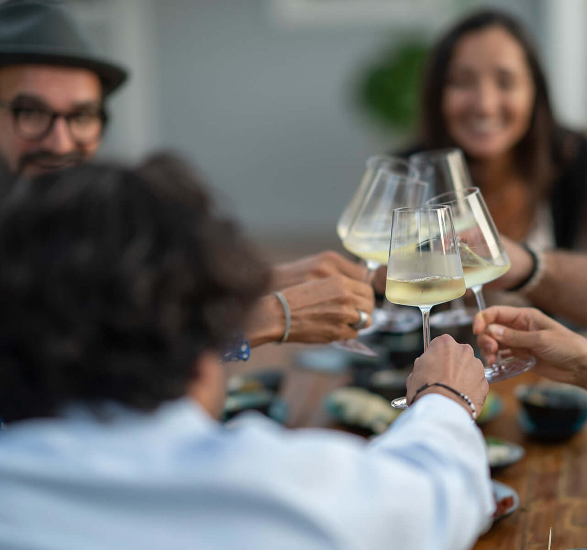 Wein Tasting für Fortgeschrittene mit Freunden, Gläser anstoßen, appetitliche Tapas und geselliges Ambiente.