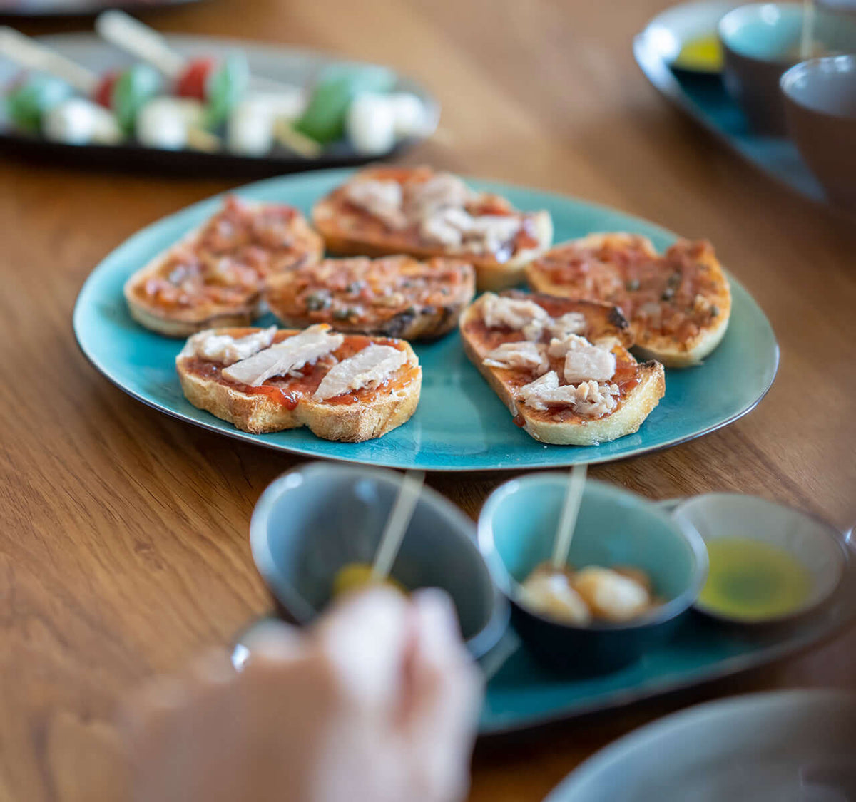 Italienisches Wein Tasting mit Antipasti: Bruschetta und Oliven auf blauem Teller, ideal für Genussliebhaber.