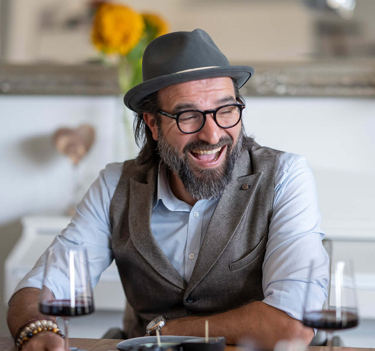 Wein Tasting für Kenner mit mobilem Service und Tapas, lächelnder Mann mit Brille und Hut, Genussmoment.
